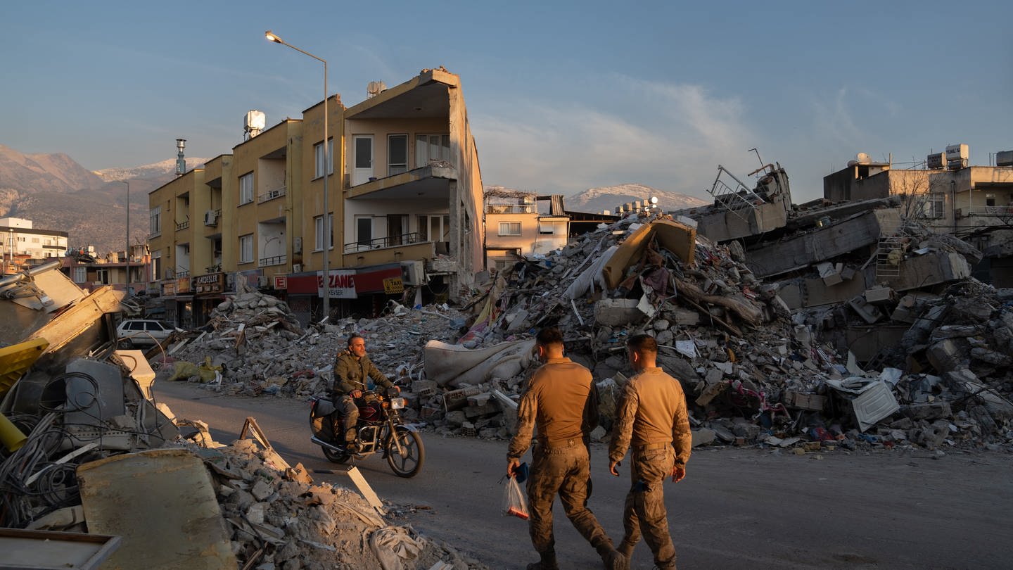 Türkei: Menschen gehen an den Trümmern zerstörter Gebäude vorbei (Foto: dpa Bildfunk, picture alliance/dpa/EUROPA PRESS | David Zorrakino)
