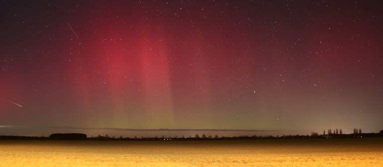 Polarlichter leuchten über Brandenburg auf dieser Nachtaufnahme mit Langzeitbelichtung. Eine starke Eruption auf der Sonne hat zu den roten und grünen Leuchteffekten in der Atmosphäre geführt, die man sonst nur im nördlichen Skandinavien oder auf Island sehen kann. (Foto: dpa Bildfunk, picture alliance/dpa | Cevin Dettlaff)