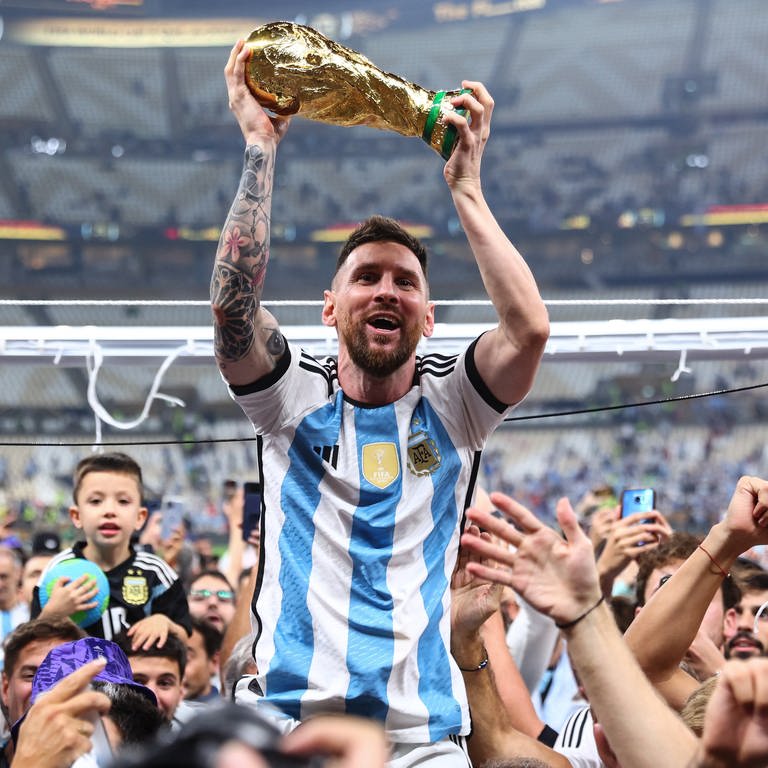 Lionel Messi lässt sich mit dem Weltmeisterpokal durchs Stadion tragen (Foto: dpa Bildfunk, picture alliance/dpa | Tom Weller)