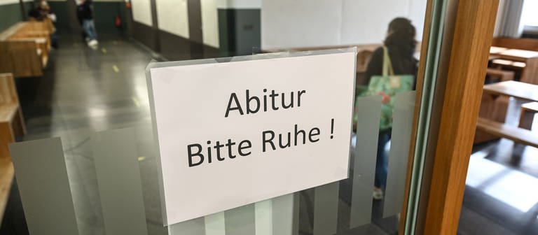 Ein Schild, auf dem "Abitur. Bitte Ruhe!" steht, hängt in einer Glastür. (Foto: dpa Bildfunk, picture alliance/dpa | Felix Kästle)