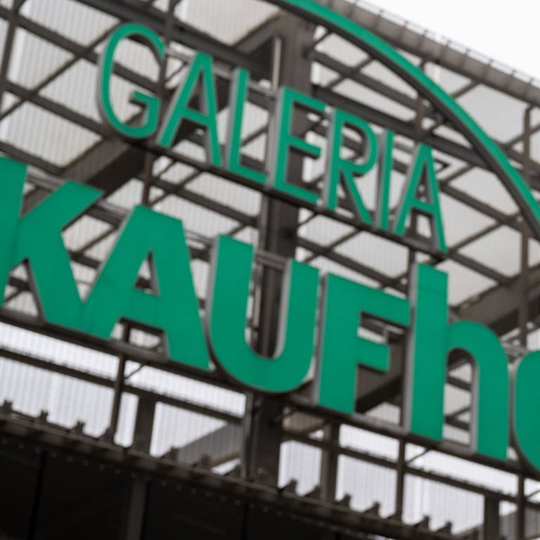 Auf Fünf vor Zwölf steht eine Uhr neben dem Logo der Galeria Kaufhof in Chemnitz. Bei der insolventen Warenhaus-Kette wird derzeit über das Ausmaß der Sanierung beraten, eine Entscheidung dazu wird erwartet. (Foto: DASDING, dpa Bildfunk, picture alliance/dpa | Hendrik Schmidt)