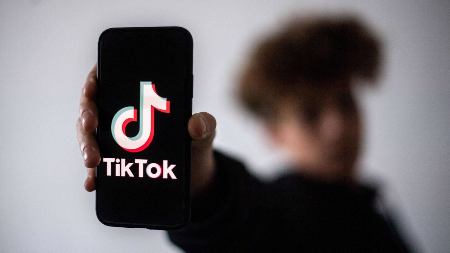 Ein Handy mit dem TikTok-Logo wird ins die Kamera gehalten (Foto: IMAGO, IMAGO / ZUMA Press)