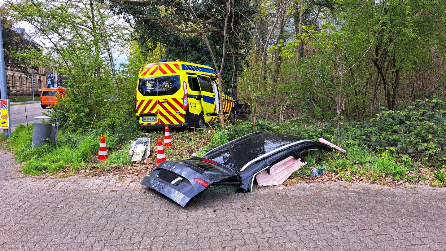 Das Dach eines Autos liegt auf dem Boden, im Hintergrund ein Krankenwagen an einem Baum (Foto: Markus Rott / EinsatzReport24)