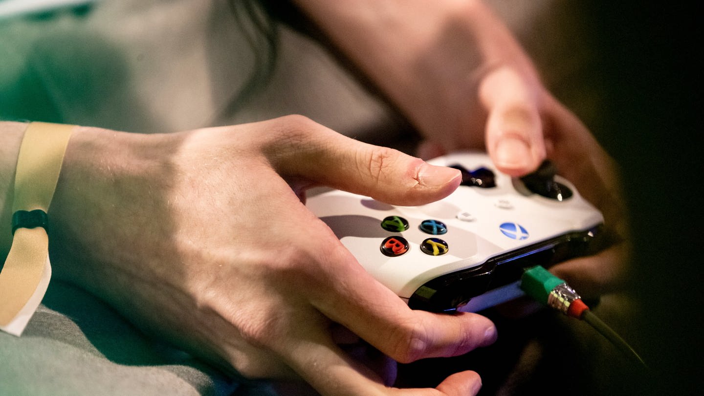 Die Hände eines Spielers sind an einem Xbox Controller zu sehen. (Foto: dpa Bildfunk, picture alliance/dpa | Christoph Soeder)