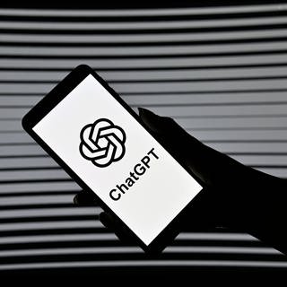 Smartphone in einer Hand mit dem ChatGPT Logo (Foto: IMAGO, IMAGO / Panama Pictures)