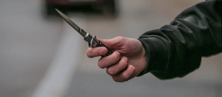 Mann mit Messer in der Hand. In Berlin griff ein Mann mit einem Messer zwei Mädchen an. (Foto: IMAGO, IMAGO / Rolf Kremming)