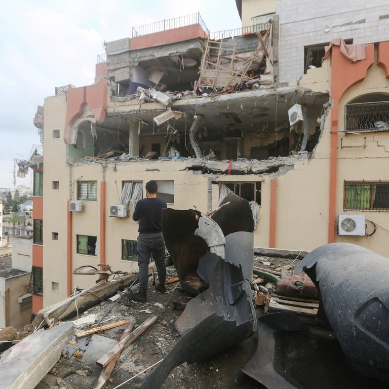 Einsatzkräfte inspizieren einen beschädigten Ort nach einer Explosion (Foto: dpa Bildfunk, picture alliance/dpa | Mohammed Talatene)
