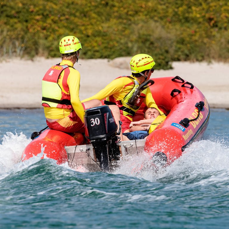 DLRG-Rettungsschwimmer bringen bei einer Übung einen Statisten im Boot zurück an den Strand. (Foto: dpa Bildfunk, picture alliance/dpa | Markus Scholz)