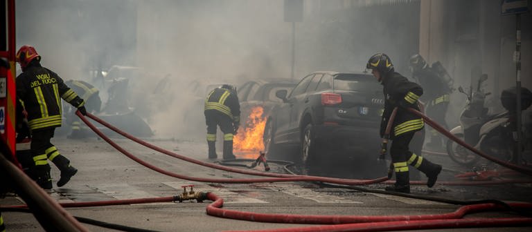 Feuerwehrleute löschen Autos nach einer Explosion in der Innenstadt von Mailand. (Foto: dpa Bildfunk, picture alliance/dpa/LaPresse via ZUMA Press | Claudio Furlan)