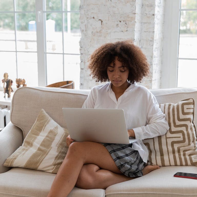 Eine Frau sitzt auf dem Sofa vor ihrem Laptop. Laut einer Studie sind immer mehr Menschen unzufrieden mit ihrem Job. (Foto: Pexels / Monstera)