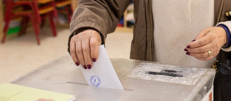 Eine Frau gibt ihre Stimme für die griechische Parlamentswahl in einem Wahllokal ab.  (Foto: dpa Bildfunk, picture alliance/dpa | Socrates Baltagiannis)