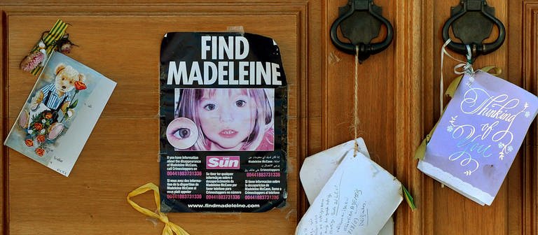 Fotos und Andenken an Madeleine McCann (Maddie) hängen am 08.08.2017 in Lagos (Portugal) an einer Kirchentür. (Foto: dpa Bildfunk, picture alliance / Lusa Forra/epa/LUSA/dpa | Lusa Forra)