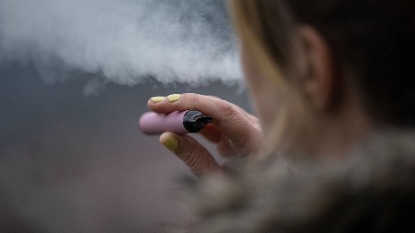 Eine junge Frau mit lackierten Fingernägeln raucht eine E-Zigarette. Der Raucheranteil von Jugendlichen in Deutschland steigt derweil. (Foto: dpa Bildfunk, picture alliance/dpa | Marijan Murat)