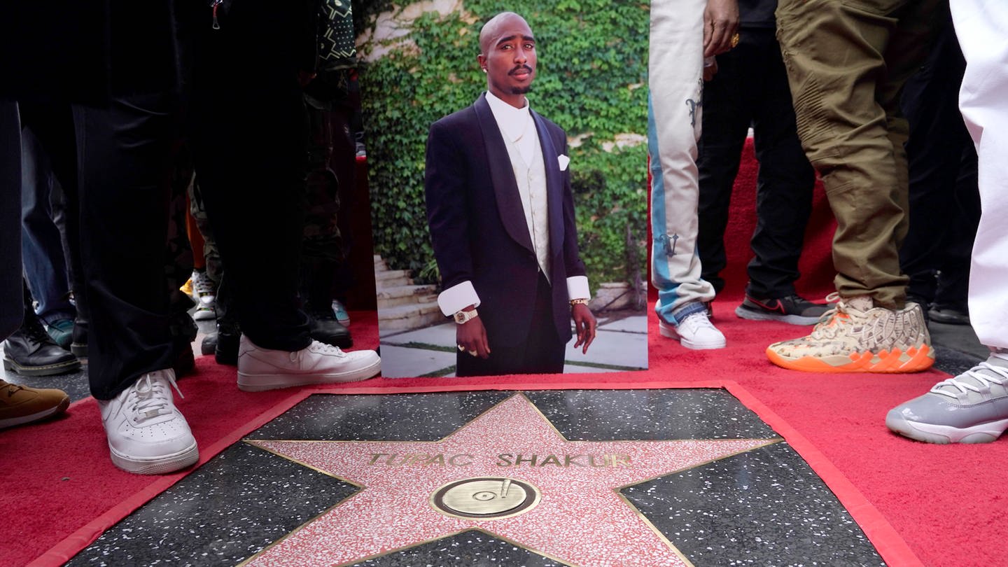 Ein Bild des verstorbenen Rappers und Schauspielers Tupac Shakur steht neben seinem Stern auf dem Hollywood Walk of Fame. (Foto: dpa Bildfunk, picture alliance/dpa/Invision/AP | Chris Pizzello)