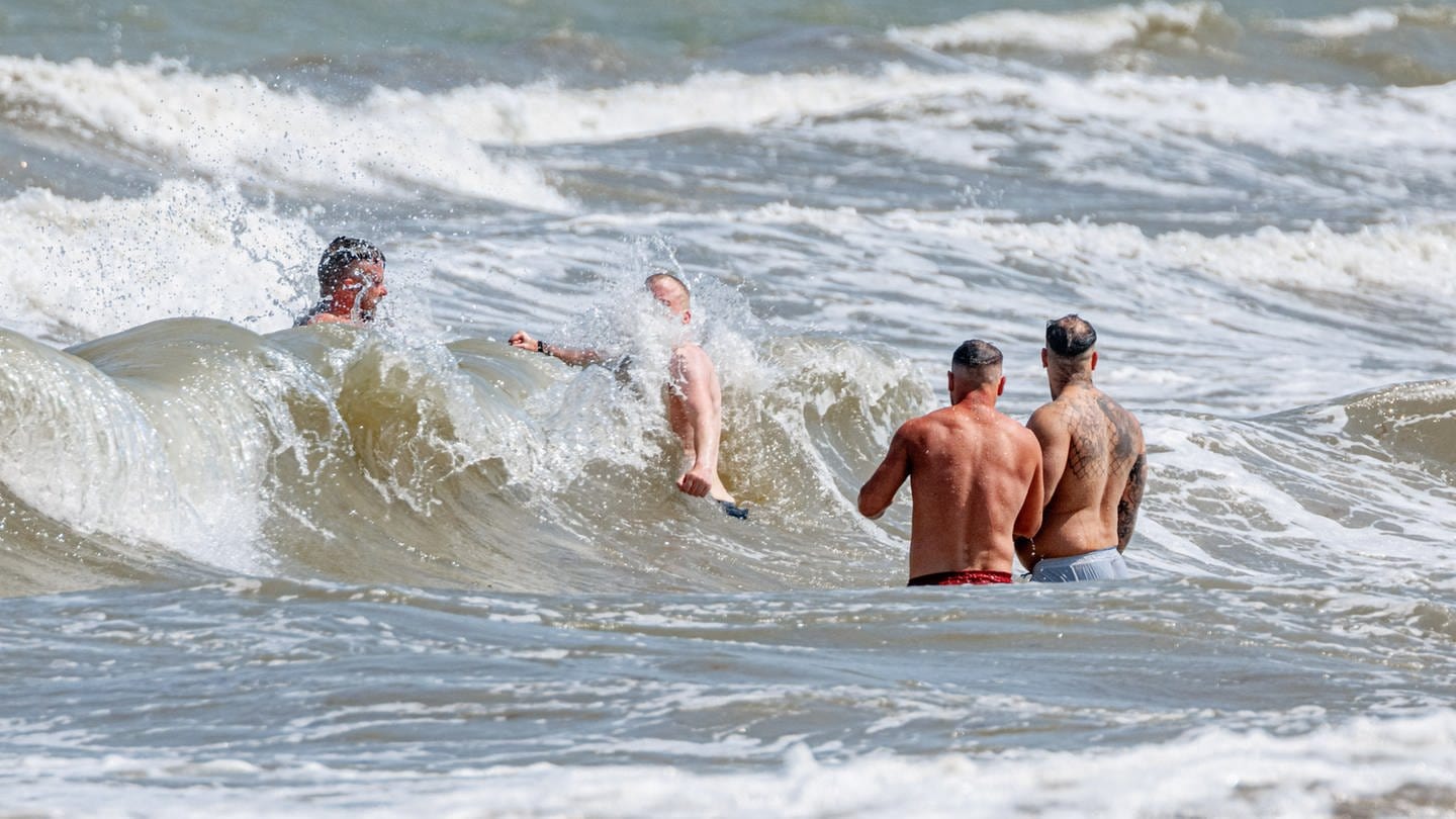 Vier Männer baden in starker Brandung vor Timmendorfer Strand. Hier hat es am Montag einen tödlichen Badeunfall gegeben. (Foto: dpa Bildfunk, picture alliance/dpa | Markus Scholz)