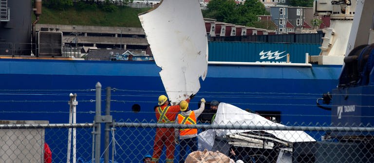 Trümmer des Tauchboots «Titan», das vom Meeresboden in der Nähe des Wracks der Titanic geborgen wurde, werden am Pier der kanadischen Küstenwache vom Schiff «Horizon Arctic» entladen.  (Foto: dpa Bildfunk, picture alliance/dpa/The Canadian Press/AP | Paul Daly)