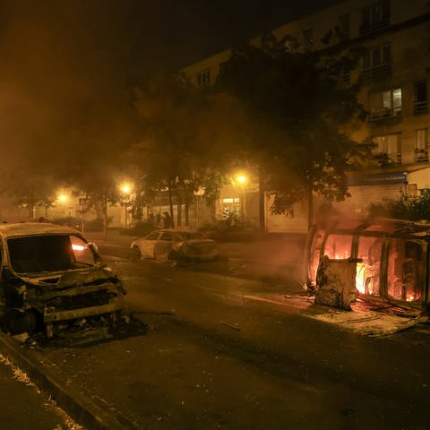 Autos brennen bei Ausschreitungen im Pariser Vorort Nanterre. Zwei Tage nach dem tödlichen Schuss eines Polizisten auf einen Jugendlichen bei einer Verkehrskontrolle bei Paris ist es erneut zu Krawallen in Frankreich gekommen. (Foto: dpa Bildfunk, picture alliance/dpa/AP | Aurelien Morissard)