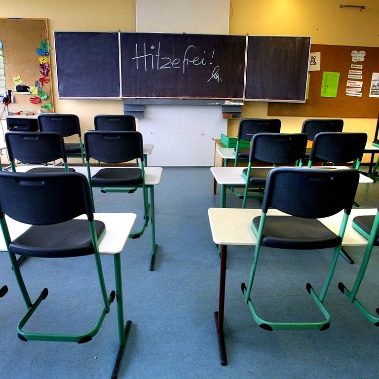 Ein leeres Klassenzimmer in einer Schule. Auf der Tafel steht "Hitzefrei". (Foto: IMAGO, Horst Rudel (Archiv))