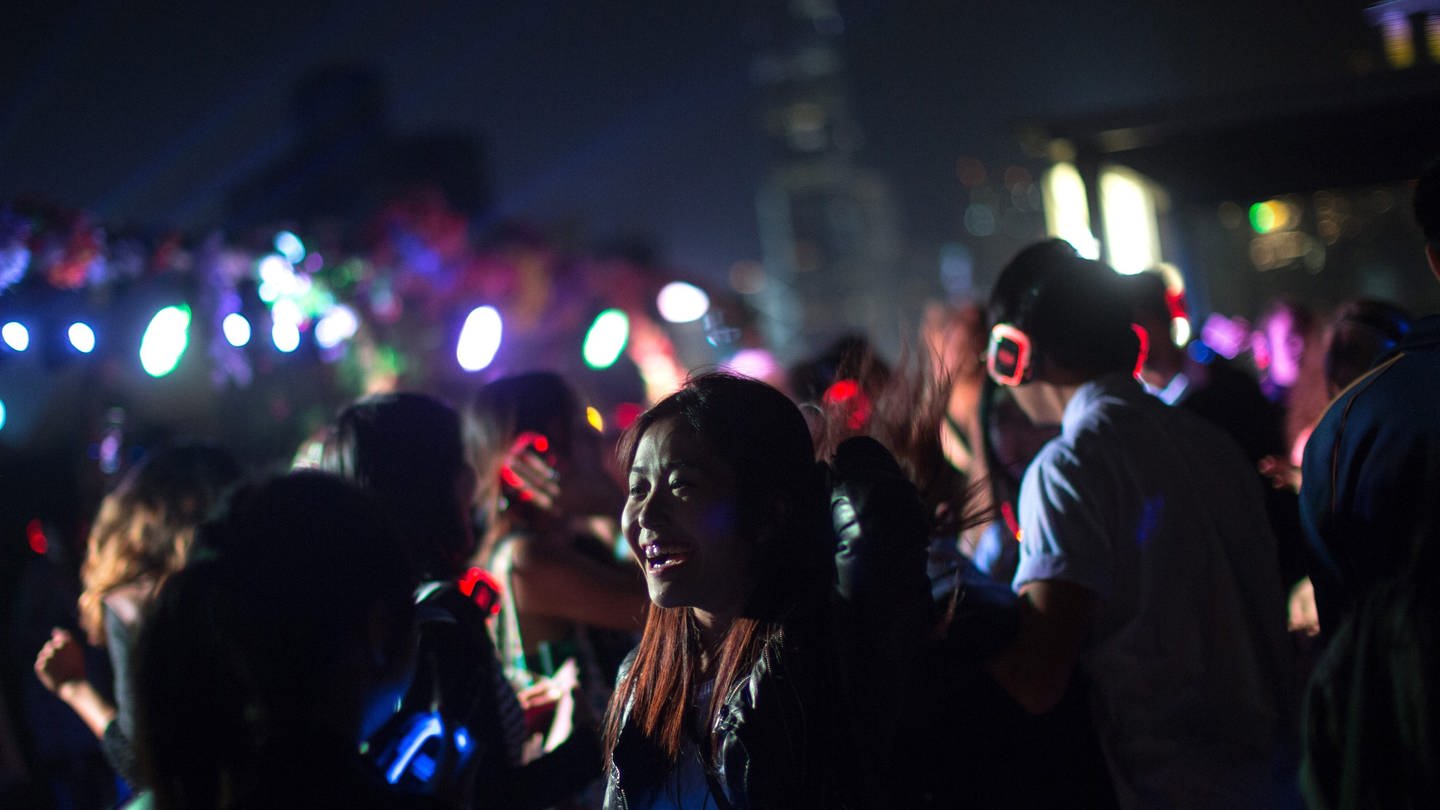 Mehrere Menschen feiern bei einem Konzert. Durch einen Vibrationsanzug sollen Gehörlose Live-Musik besser spüren können. (Foto: dpa Bildfunk, Picture Alliance)