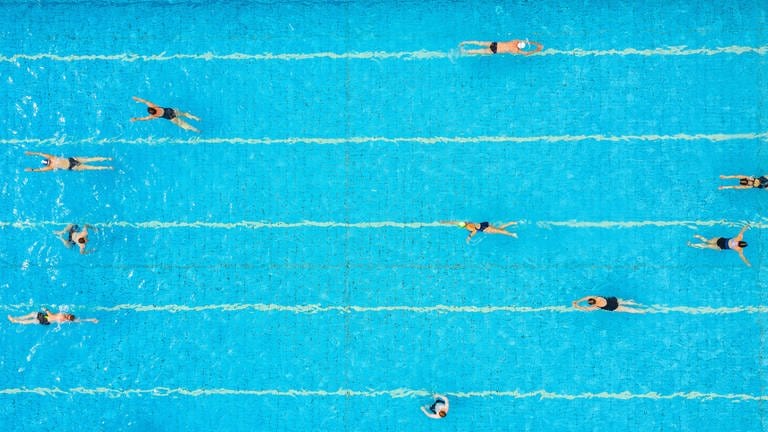 Menschen schwimmen ihre Bahnen in einem Schwimmbad (Symbolfoto). (Foto: dpa Bildfunk, picture alliance/dpa | Guido Kirchner)