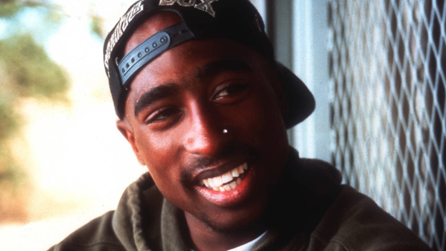 Tupac Shakur lacht in die Kamera (Foto: IMAGO, IMAGO / Ronald Grant)