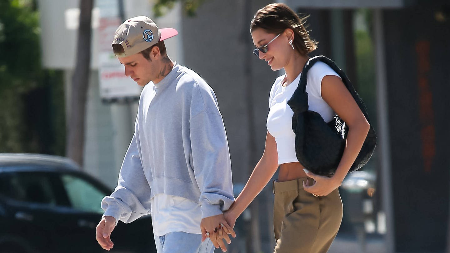 Hailey und Justin Bieber laufen händchenhalten über eine Straße. (Foto: IMAGO, Cover-Images)