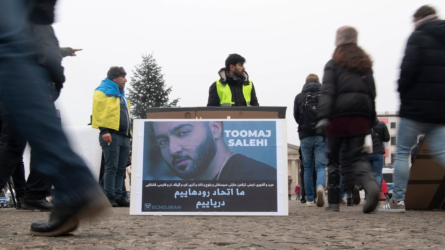 Ein großes Plakat steht bei einer Protestaktion gegen das Iran-Regime auf dem Pariser Platz. Es zeigt den iranischen Rapper Toomaj Salehi. (Foto: dpa Bildfunk, picture alliance/dpa | Paul Zinken)