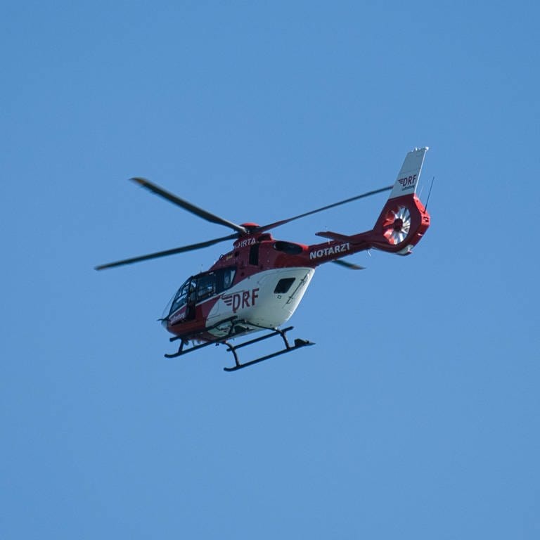 Ein Rettungshubschrauber fliegt am Himmel. (Foto: IMAGO, IMAGO / bodenseebilder.de)