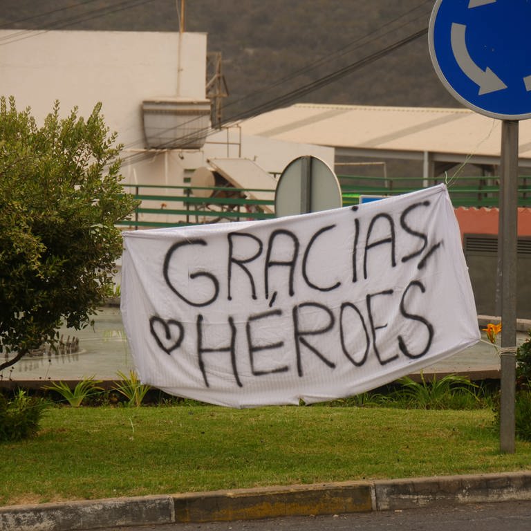 Ein Banner mit der Aufschrift "Gracias Heroes" ist an einem Kreisverkehr gespannt. Seit letztem Dienstag wütet auf Teneriffa ein Waldbrand - jetzt entspannt sich die Lage. (Foto: dpa Bildfunk, picture alliance/dpa/TNN | Patrick Kerber)