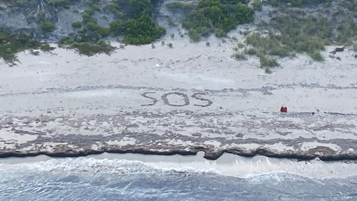 Das Foto zeigt die Buchstaben «SOS», die von einem 64-jährigen Mann in den Sand gezeichnet wurden, der drei Tage lang auf einer Insel in den Bahamas gestrandet war, bis er gerettet wurde. (Foto: dpa Bildfunk, picture alliance/dpa/U.S. Coast Guard/AP | Uncredited)