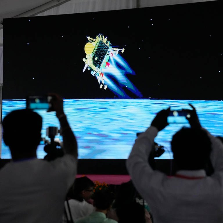 Journalisten filmen die Live-Übertragung der Landung des Raumschiffs «Chandrayaan-3» auf dem Mond  (Foto: dpa Bildfunk, picture alliance/dpa/AP | Aijaz Rahi)