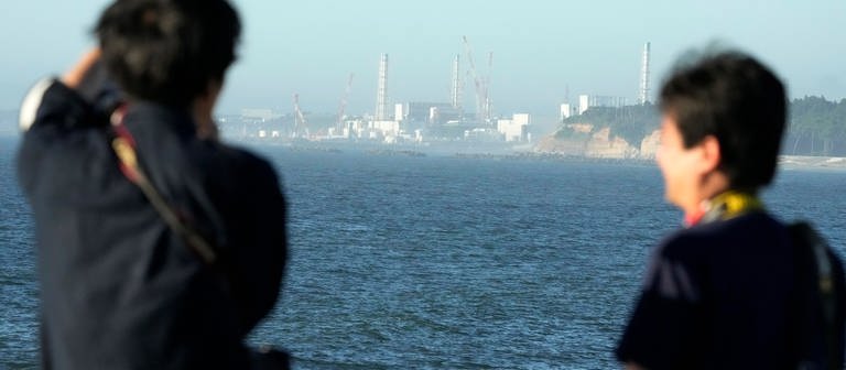 Das Kernkraftwerk Fukushima Daiichi ist vom nahegelegenen Fischereihafen Ukedo in der Stadt Namie zu sehen. Gut zwölf Jahre nach dem Super-GAU in Fukushima beginnt Japan mit der Ableitung aufbereiteten Kühlwassers aus der Atomruine ins Meer. (Foto: dpa Bildfunk, picture alliance/dpa/AP | Eugene Hoshiko)