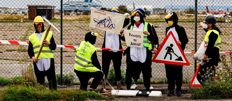 Klimaaktivisten in Pinguinkostümen als Pinguin verkleidet wollen Privatjets auf Sylt am Abflug hindern (Foto: dpa Bildfunk, picture alliance/dpa | Axel Heimken)