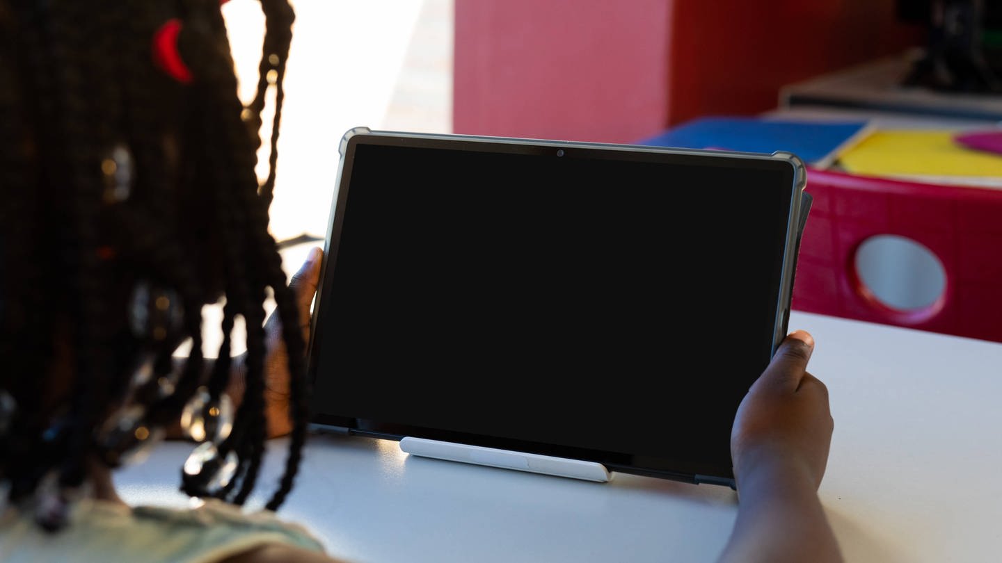 Mädchen vor Tablet in Schule. (Foto: IMAGO, IMAGO / VectorFusionArt)