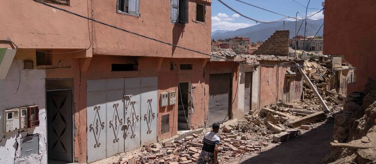 Ein Mann rennt in der Stadt Amizmiz in der Nähe von Marrakesch, um Gegenstände aus seinem Haus zu bergen. In Marokko ist es zu einem heftigen Erdbeben gekommen.  (Foto: dpa Bildfunk, picture alliance/dpa/AP | Mosa'ab Elshamy)