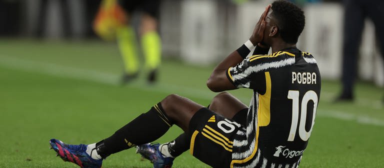 Der verletzte Paul Pogba von Juventus hält sich die Hände vor das Gesicht und sietzt auf dem Spielfeld. (Foto: dpa Bildfunk, picture alliance/dpa/Zuma Press | Jonathan Moscrop)