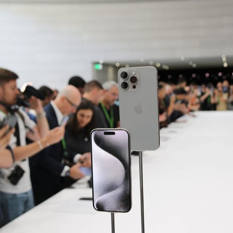 Journalisten umlagern auf dem Apple-Event das neue iPhone 15 Pro im Steve-Jobs-Theater auf dem Firmencampus. Bei dem Apple-Event wurde die neue Generation vorgestellt. (Foto: dpa Bildfunk, picture alliance/dpa | Christoph Dernbach)