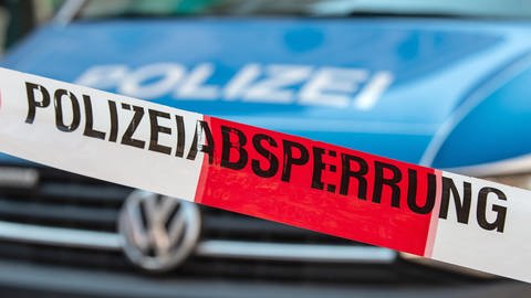 Ein Flatterband mit der Aufschrift "Polizeiabsperrung" ist vor einem Fahrzeug der Polizei zu sehen. Bei Neubrandenburg soll ein sechsjähriger Junge getötet worden sein. (Foto: dpa Bildfunk, picture alliance/dpa | Swen Pförtner)