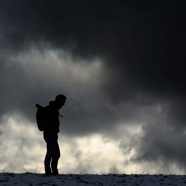 Ein Mann steht vor einem dunklen Himmel (Symboldbild) Tipps: So bekommst du einen Therapieplatz