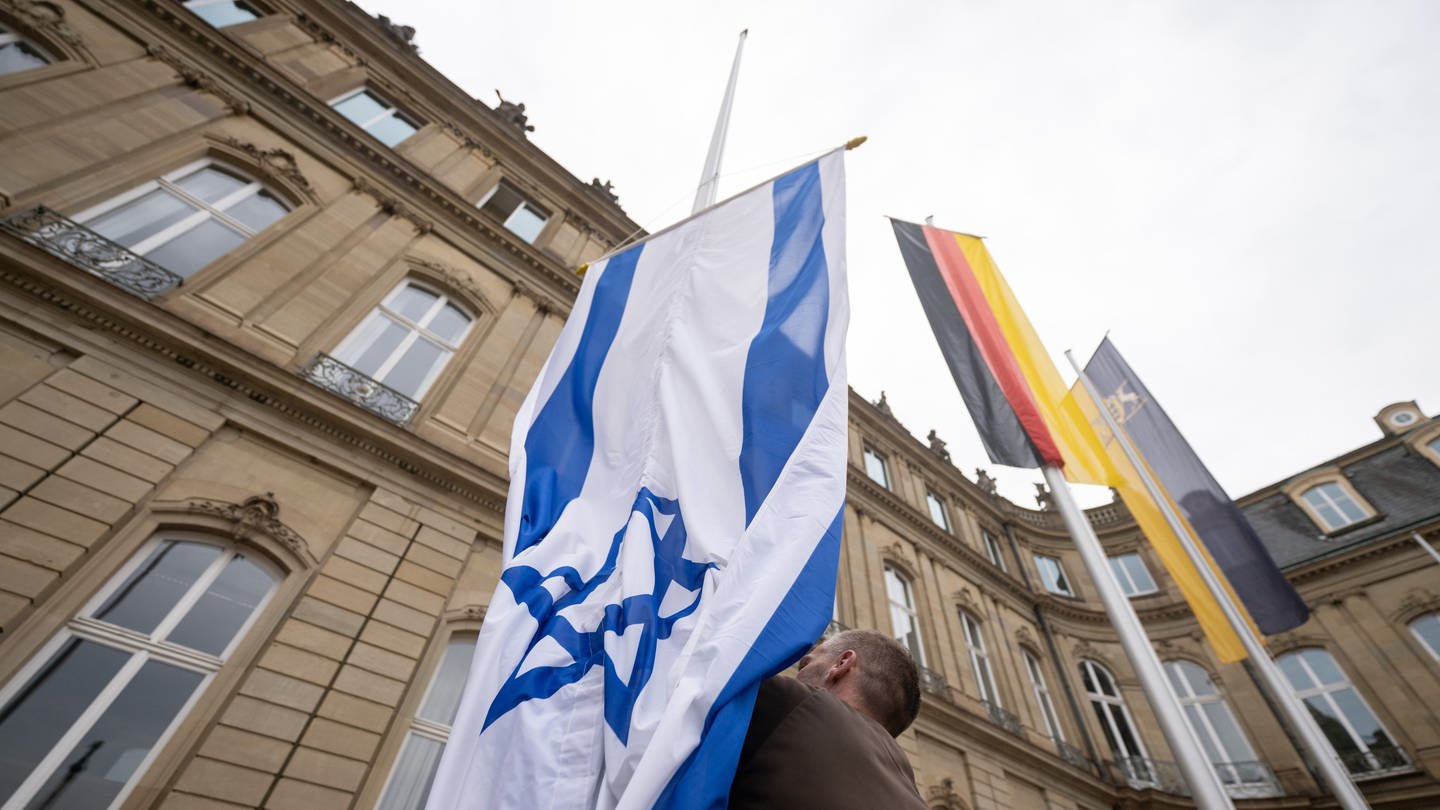 Die Flagge Israels wird von einem Mitarbeiter des Staatsministeriums Baden-Württemberg zwischen den Flaggen der EU, Deutschlands und Baden-Württembergs gehisst. (Foto: dpa Bildfunk, picture alliance/dpa | Marijan Murat)