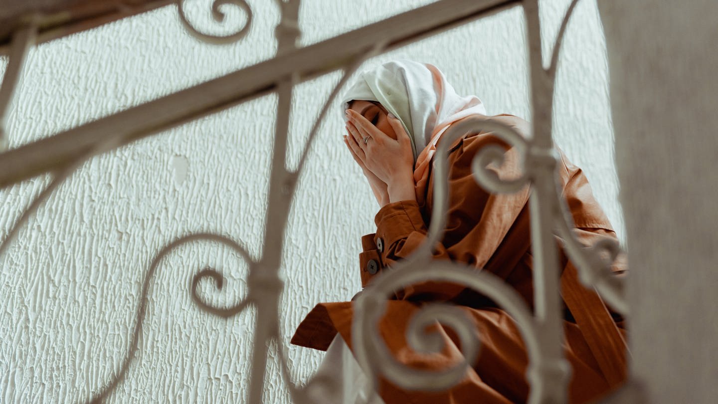 Frau sitzt traurig auf Treppe (Foto: Pexels / Mikhail Nilov)