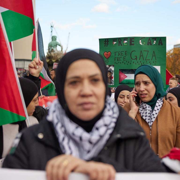 Teilnehmer einer Pro-Palästina-Kundgebung am Neptunbrunnen in Berlin halten ein Plakat mit der Aufschrift „Free Palestine" (04.11.2023). (Foto: dpa Bildfunk, picture alliance/dpa | Jörg Carstensen)