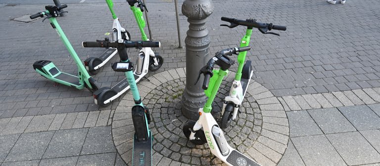 E-Scooter verschiedener Anbieter stehen auf dem Gehweg. - In Mainz soll es jetzt Parkzonen für die Leih-Roller geben (Foto: dpa Bildfunk, picture alliance/dpa | Arne Dedert)