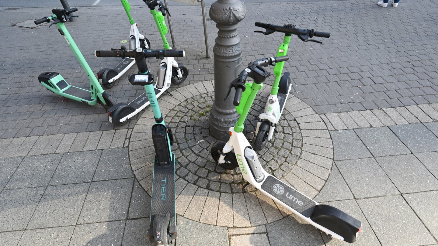 E-Scooter verschiedener Anbieter stehen auf dem Gehweg. - In Mainz soll es jetzt Parkzonen für die Leih-Roller geben (Foto: dpa Bildfunk, picture alliance/dpa | Arne Dedert)
