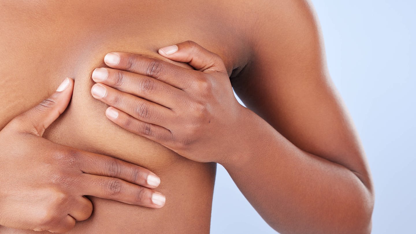 Eine Frau tastet ihre Brust nach Knoten ab. Etwa 290 000 Frauen in Großbritannien könnten künftig vorbeugend ein Medikament gegen Brustkrebs nehmen. (Foto: IMAGO, IMAGO / Zoonar)