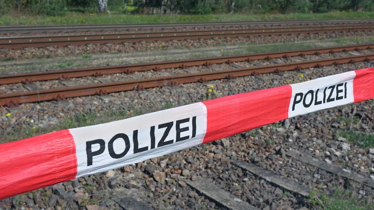 Absperrband der Polizei vor Gleisen: In Bobenheim-Roxheim wurde ein 19-Jähriger tot neben Bahngleisen gefunden (Symbolbild) (Foto: SWR DASDING, IMAGO / Steinach)