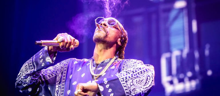 So kannte man ihn lange Zeit: Snoop Dogg auf einem Konzert in Rotterdamm, während er einen Joint auf der Bühne raucht. Damit soll jetzt Schluss sein. (Foto: IMAGO, IMAGO / ANP)