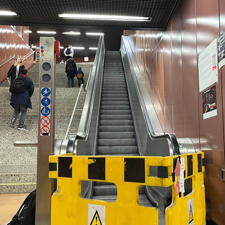 Stuttgart: An der S-Bahn-Haltestelle Universität ist eine Rolltreppe defekt. Fahrgäste reagieren mit Memes, die sie auf den Bauzaun kleben. (Foto: SWR DASDING, SWR / Philipp Pfäfflin)