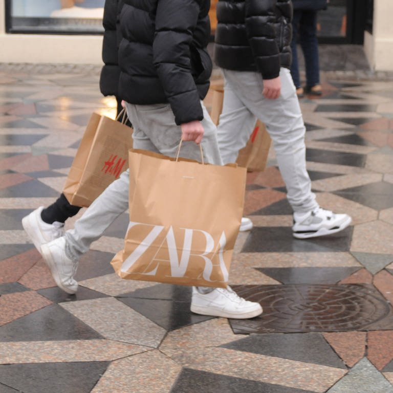Zwei Jugendliche mit Einkaufstaschen von Zara und H&M: Bei Zara gibt es online bald Secondhand-Mode zu kaufen (Foto: IMAGO, IMAGO / Dean Pictures)