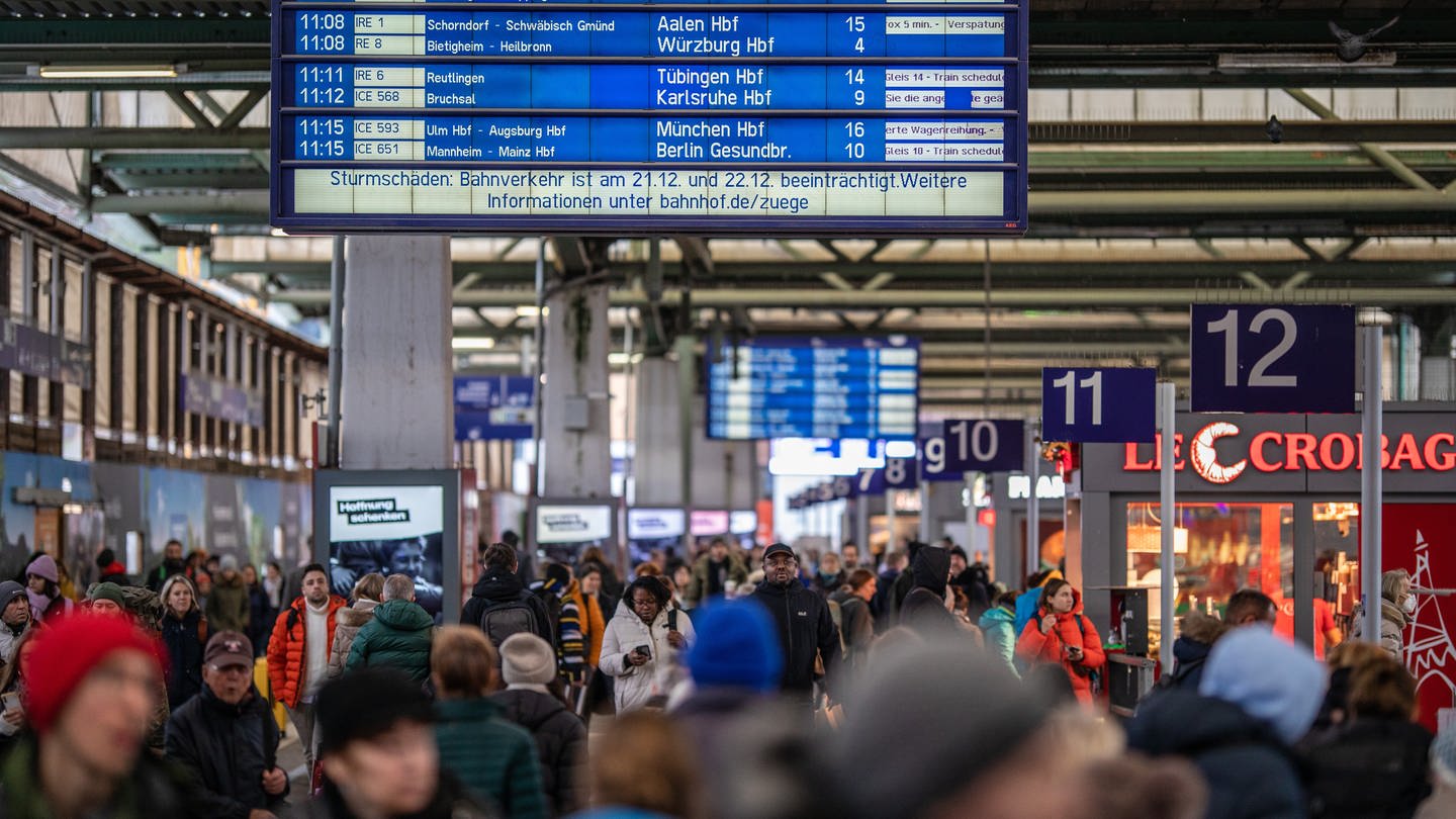 Während eine Anzeigetafel die aktuellen Abfahrten der Züge und den Hinweis auf mögliche Zugausfälle bezüglich des Sturms Zoltan anzeigt, laufen Reisende durch den Stuttgarter Hauptbahnhof. (Foto: dpa Bildfunk, picture alliance/dpa | Christoph Schmidt)